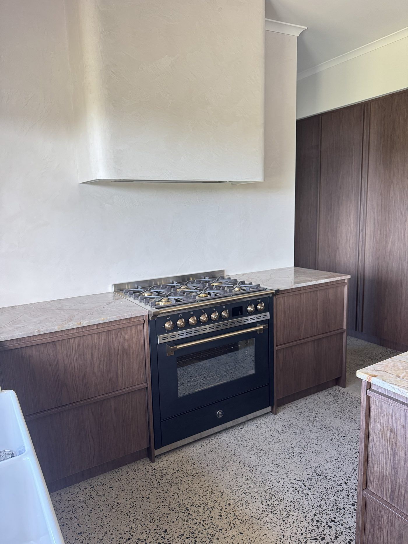 Kitchen with hand-finished textured rangehood and walls
