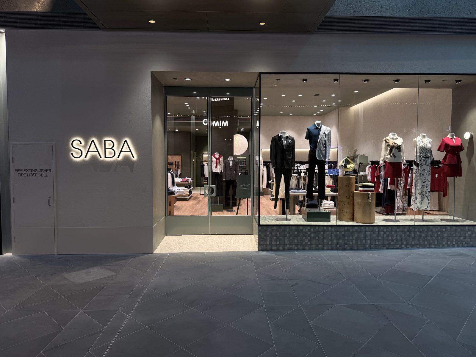Retail shopfront with textured render and lit signage